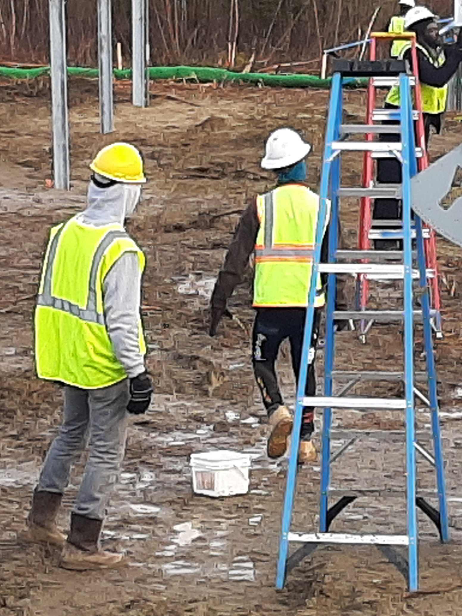 A group of construction workers walking on the ground.